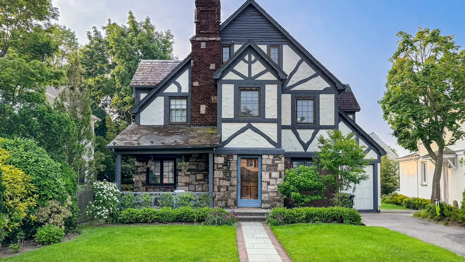 Manicured lawn, trimmed hedges and stone walkway on a landscaped Dallas home